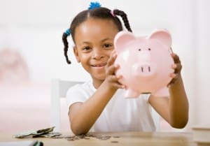Responsible girl putting money into piggy bank for future savings